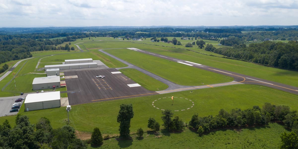 Aerial photograph of Russell County Airport's ramp, hangars, segmented-circle windsock, and taxiway, with Runway 17/35 beyond
