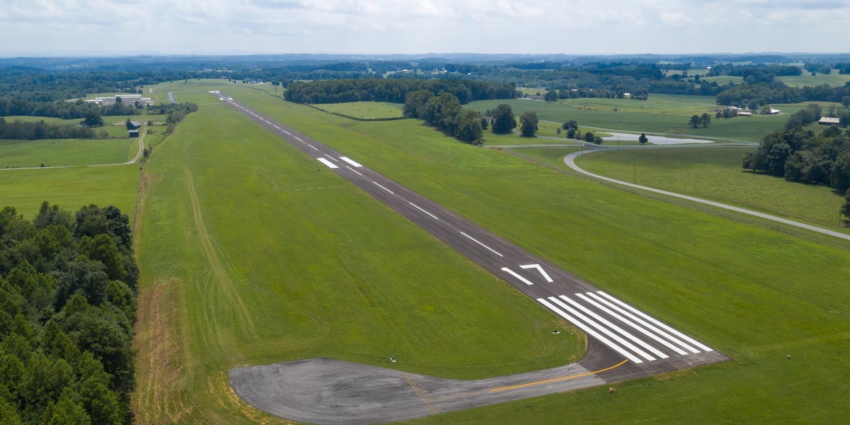 Aerial photograph of Russell County Airport's Runway 17 threshold, its painted markings and centerline crossing green Kentucky farmland