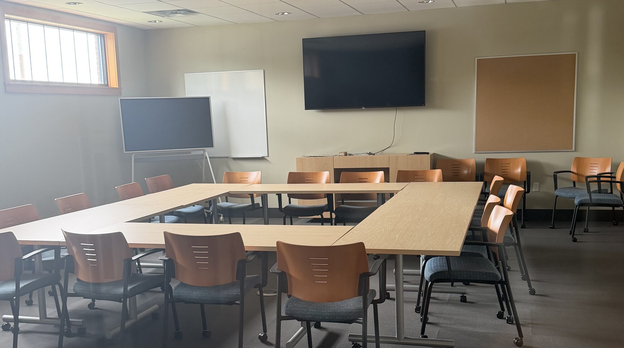 The conference room at Russell County Airport's terminal, with tables arranged in a hollow square and a wall-mounted display