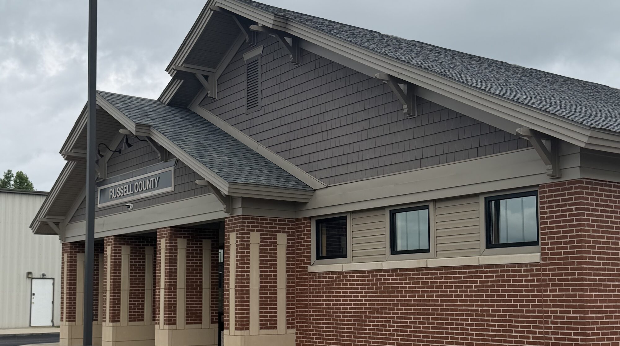 The brick terminal building at Russell County Airport, with its covered entry and Russell County sign under an overcast Kentucky sky